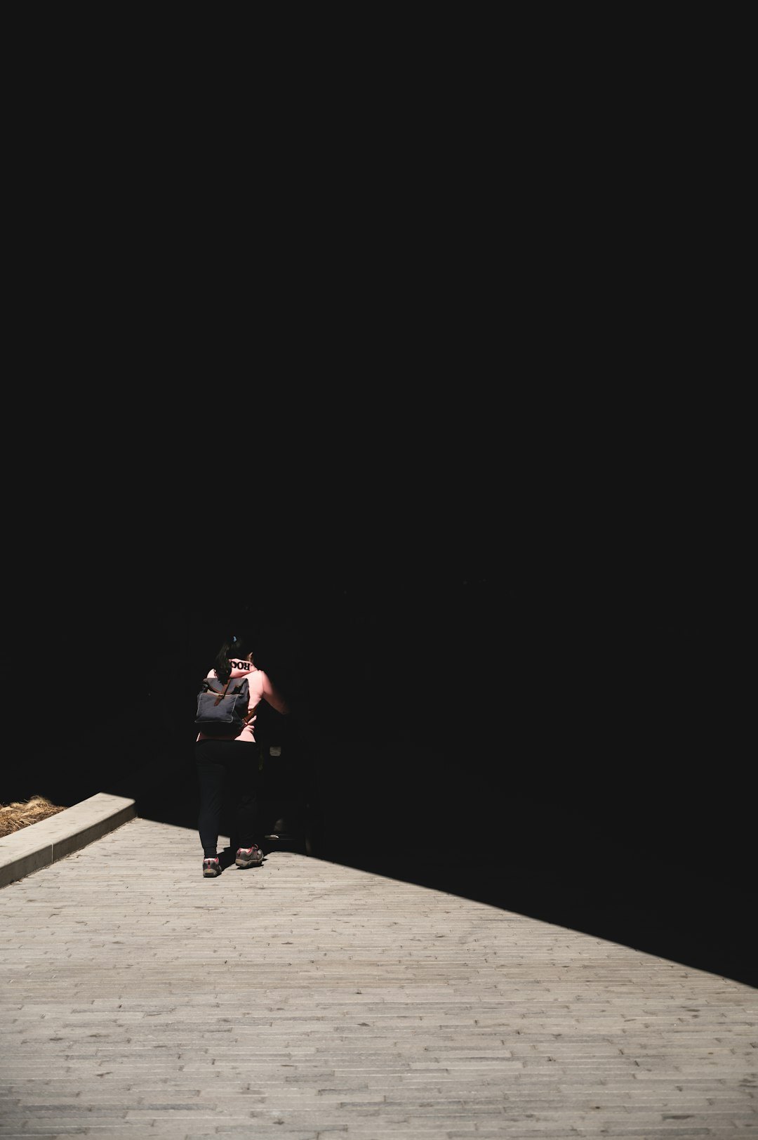 person in shadows on street