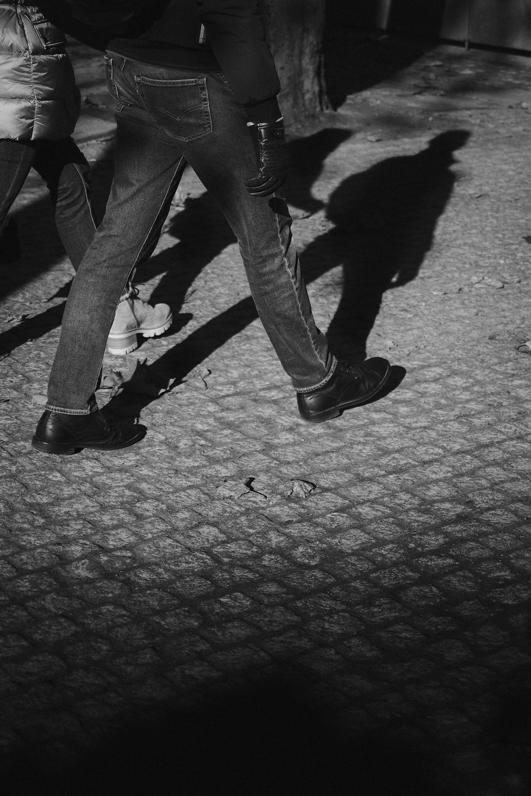 person in shadows on street